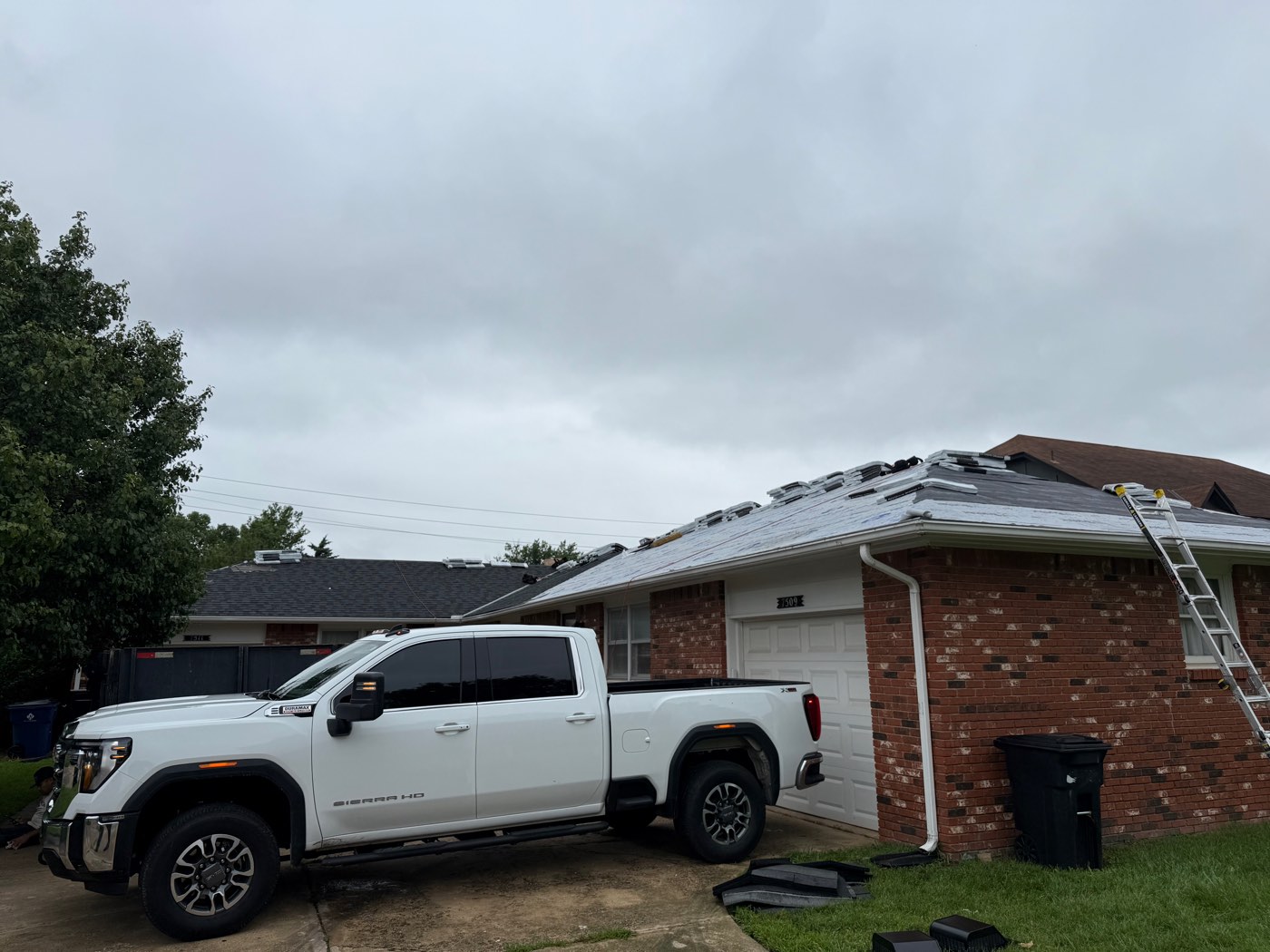 Roof replacement in progress on a brick ranch home